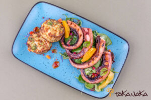 Grilled calamari tentacles with baked potatoes and citrus salad mix