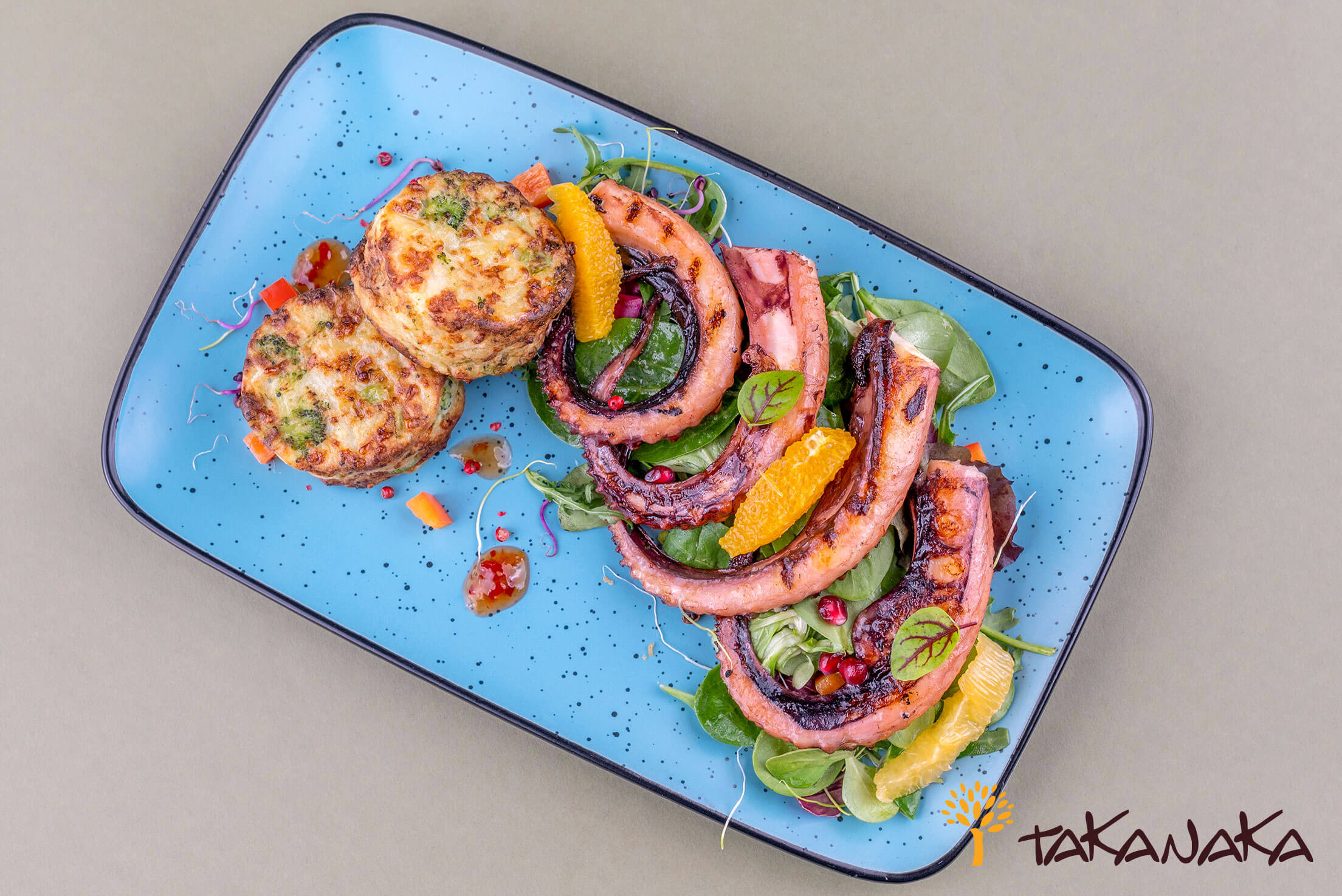 Grilled calamari tentacles with baked potatoes and citrus salad mix